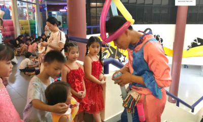 Clown making cute balloons for children at PEB Steel party